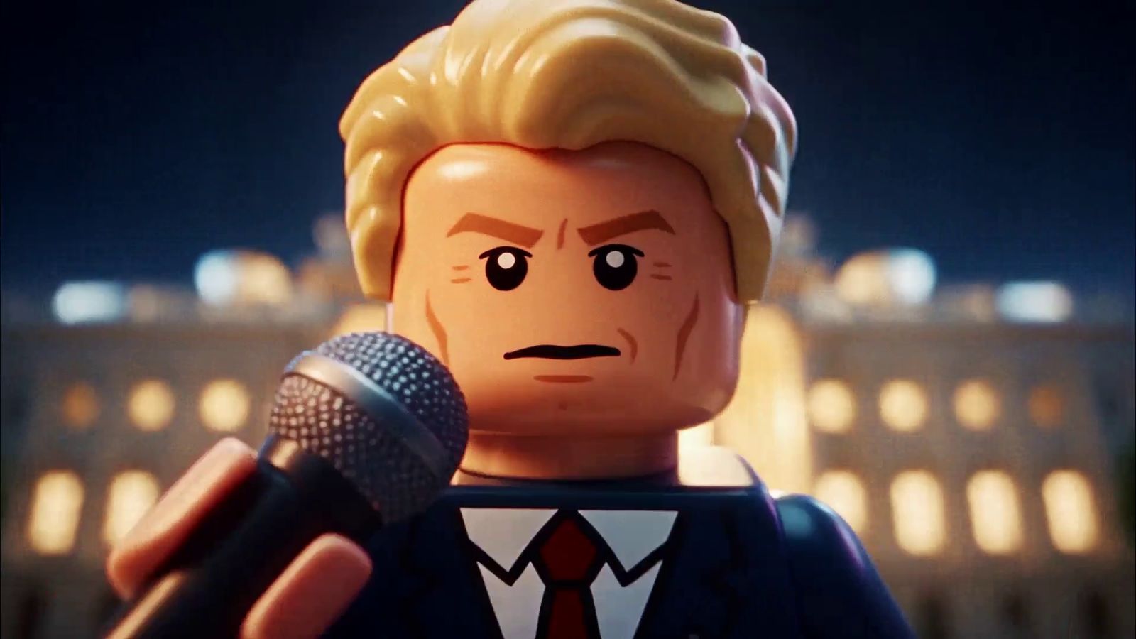 Lego Trump holding a microphone with the White House lit behind him at night